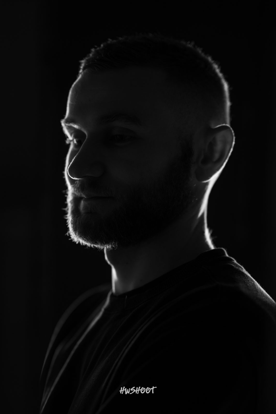 Low-key black and white male portrait photography in Calgary with dramatic rim lighting