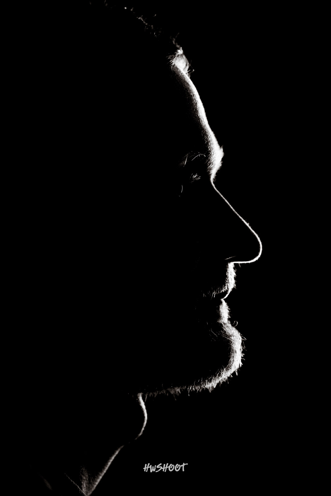 Dramatic low-key male profile portrait photography in Calgary with rim lighting