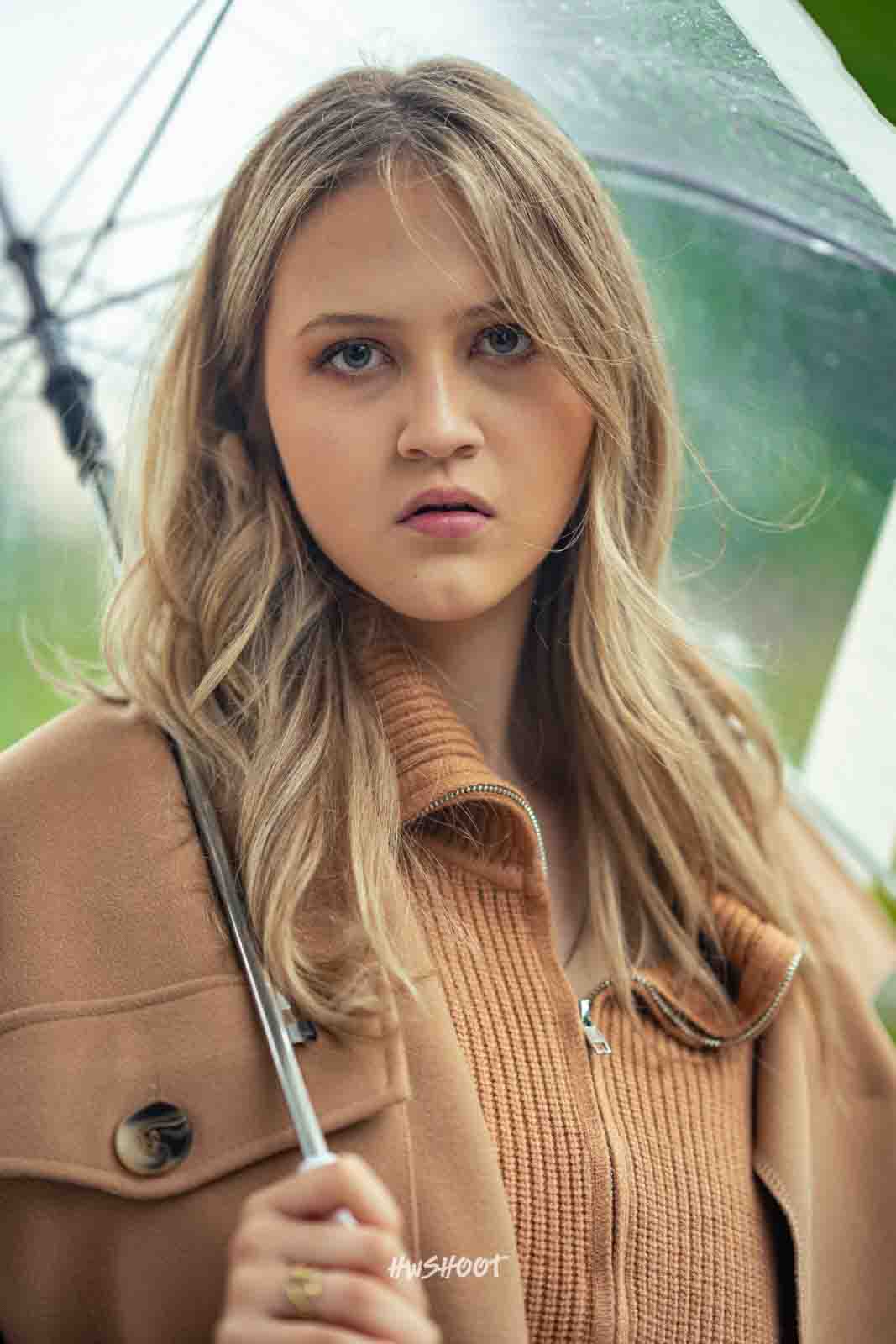 Close-up portrait of model holding a transparent umbrella